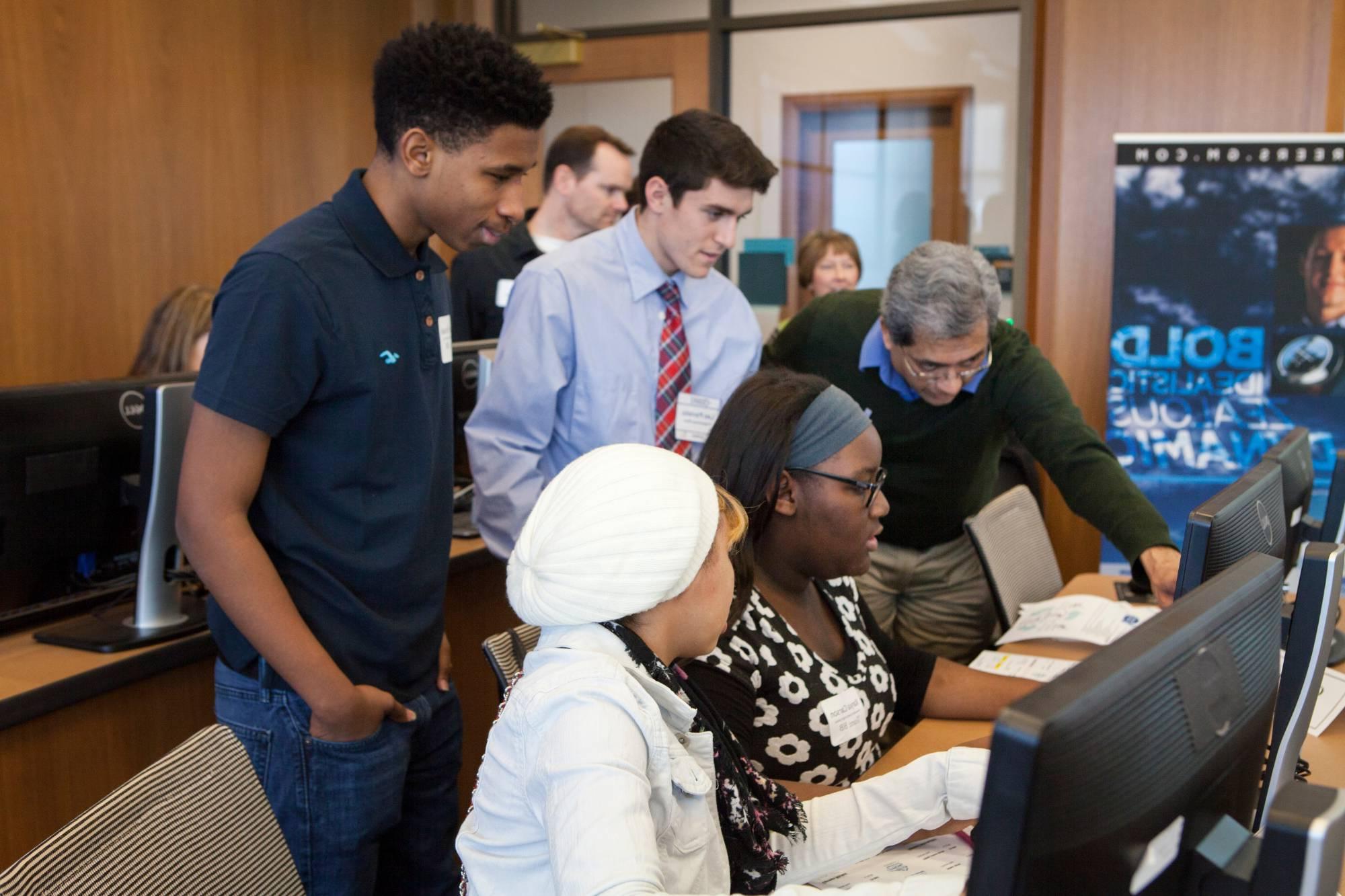 Students working in a computer lab with a GVSU faculty member